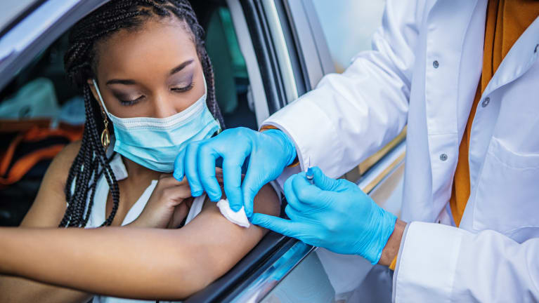 woman getting vaccine shot at drive-up site