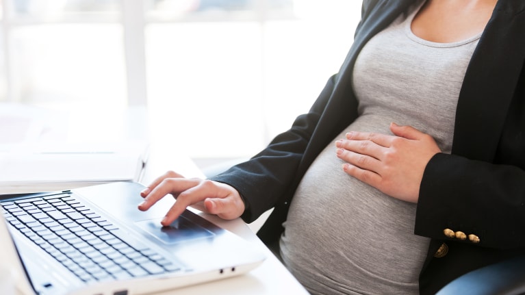pregnant business woman working on computer