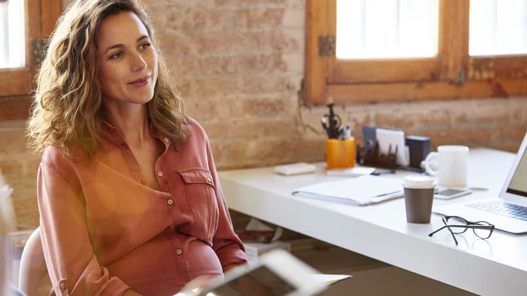 Pregnant businesswoman sitting at desk