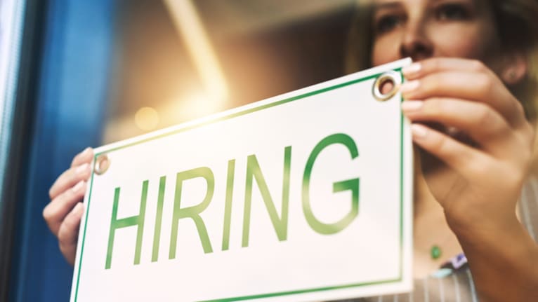 woman hanging hiring sign