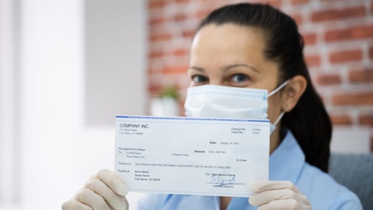 open paycheck wearing surgical mask during pandemic