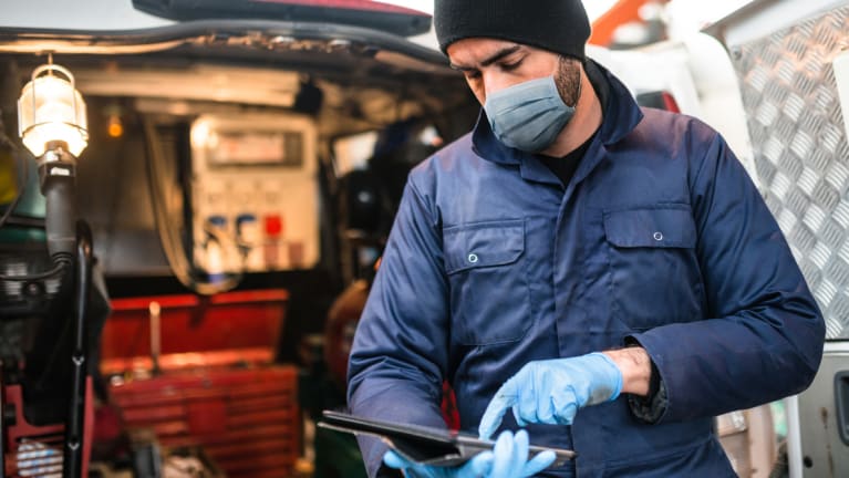 Mechanic in front of a van wearing a face mask