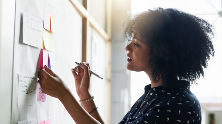 women working out schedule on bulletin board