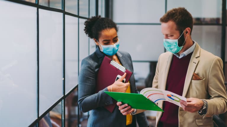 Business people wearing protective face masks at work
