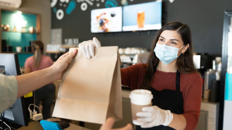 Barista wearing a mask and handling an order