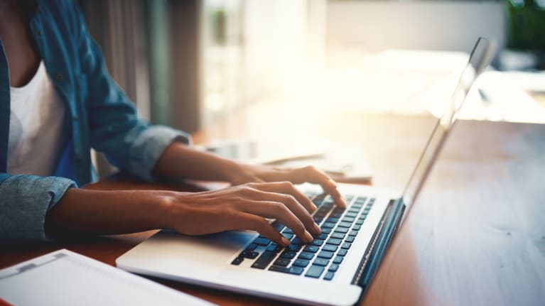 Someone typing on a laptop