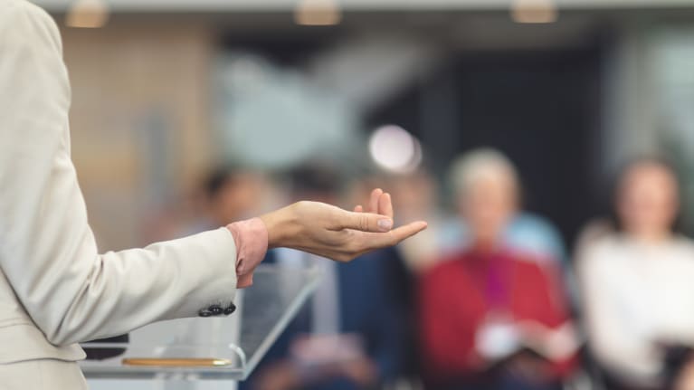 woman speaks to conference session
