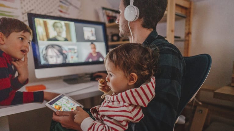 man on video call, holding kids