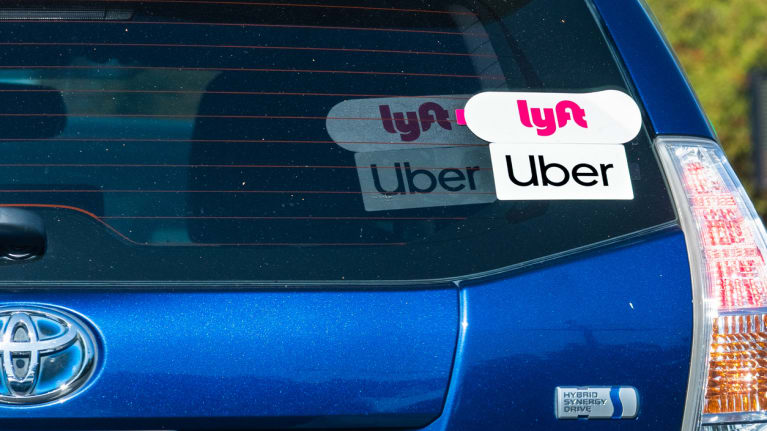 A car with Lyft and Uber stickers on the back windshield