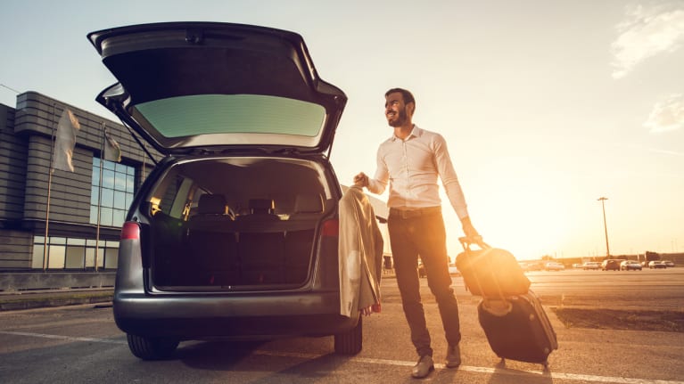 businessman with suitcase by car