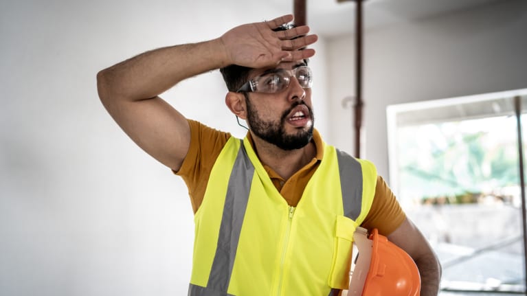 worker wiping sweat from forehead