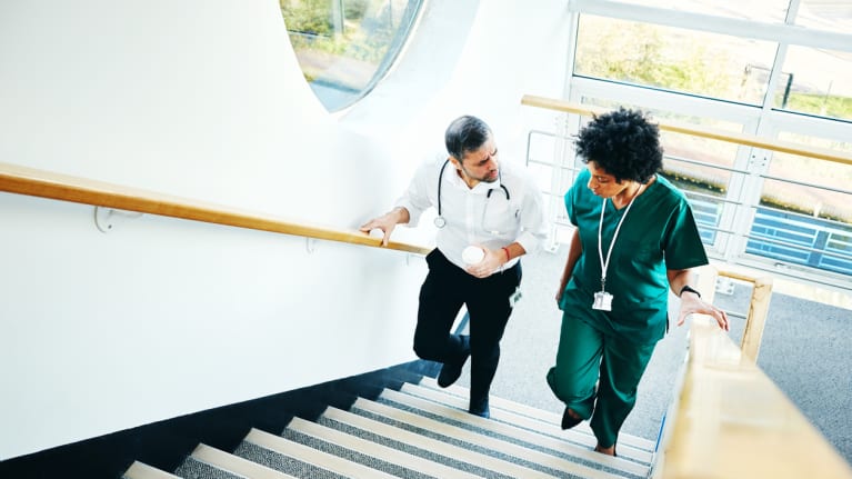 Two hospital employees havinig a discussion in a stairwell