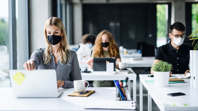 office workers wearing masks and distancing