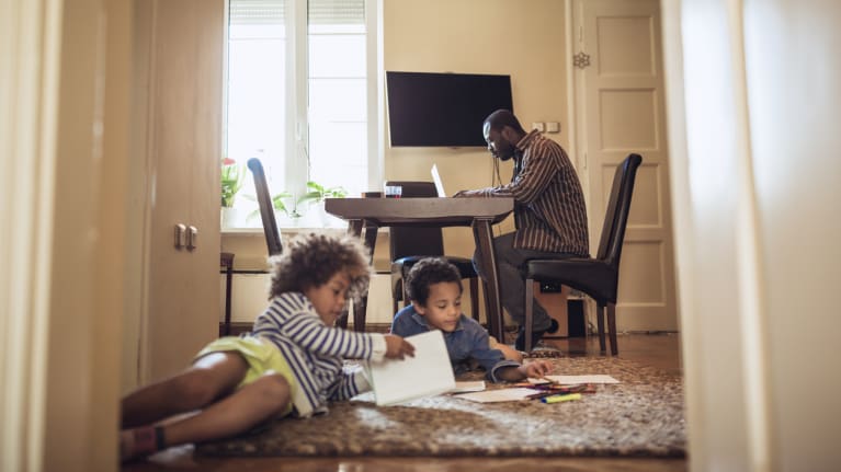 dad working from home as kids play on the floor