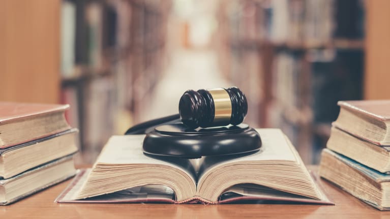 a gavel on an open lawbook in a library