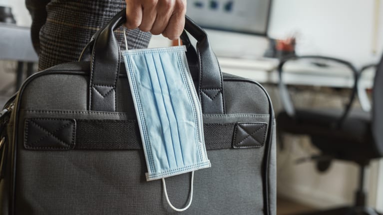 Man with a briefcase and a surgical mask