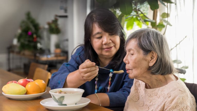 woman feeding soup to elderly person