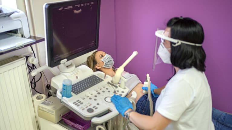 an ultrasound technician conducting an ultrasound on a pregnant woman