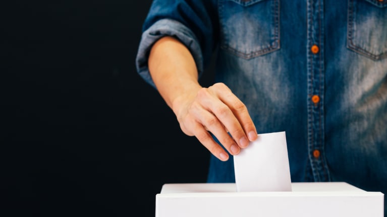 voter putting ballot in ballot box