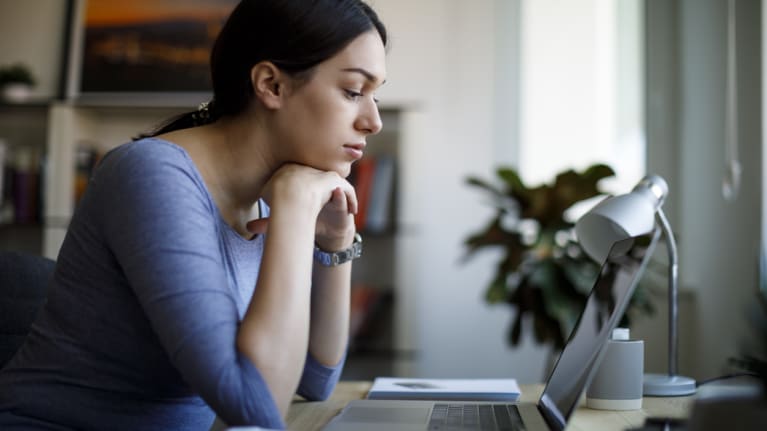 Worried woman working on laptop at home