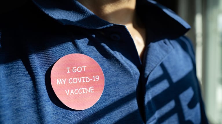 covid vaccine sticker on polo shirt