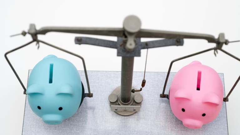 a scale with a blue piggy pank on one side and pink piggy bank on the other