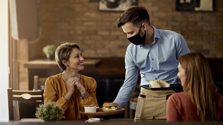 A waiter serving two customers