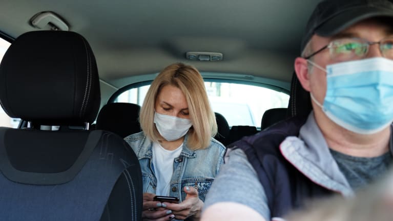 ride-share driver and passenger wearing masks