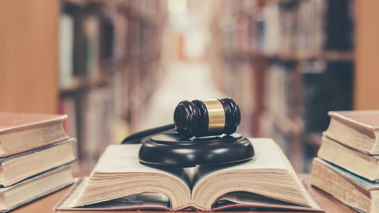 A gavel on a law book in a law library