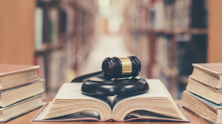 A law book with a gavel on it in a library