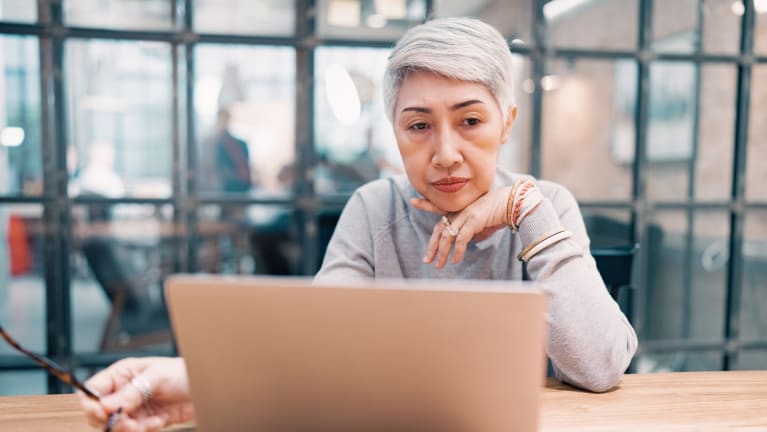 woman with gray hair working on laptop