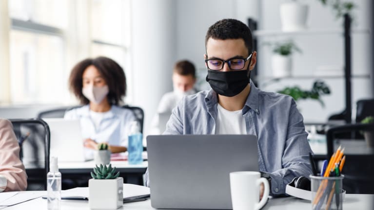 Office workers wearing masks and distancing