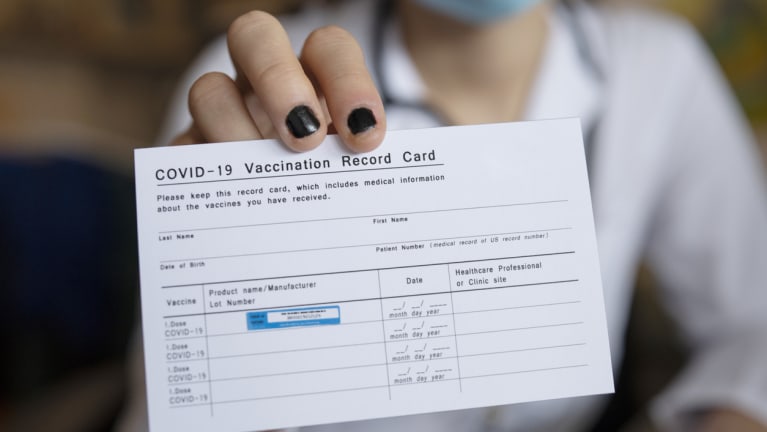 woman holding generic COVID-19 vaccination card