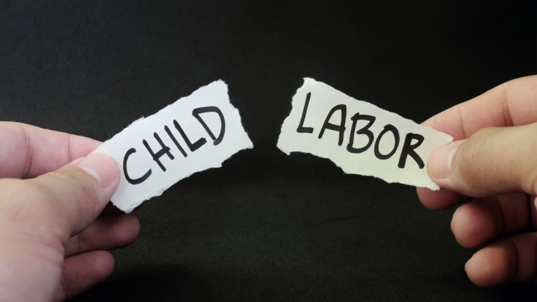The words &quot;child labor&quot; on a piece of paper split in half between the two words