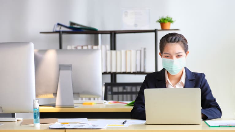 businesswoman wearing mask at desk