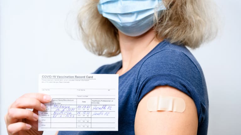 woman showing vaccine card