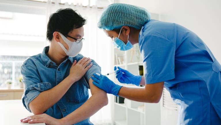 nurse giving vaccine shot to patient