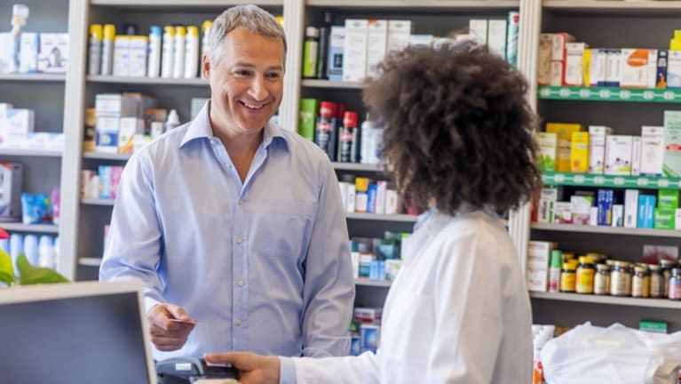 man buying prescription drugs at counter