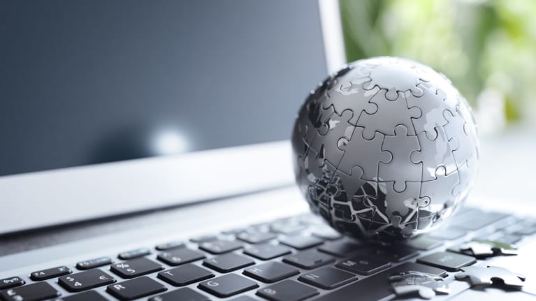 a laptop with a model of a globe on the keyboard