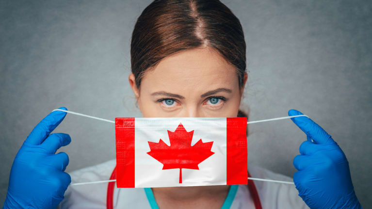 a female doctor with a surgical mask that has the Canadian flag on it