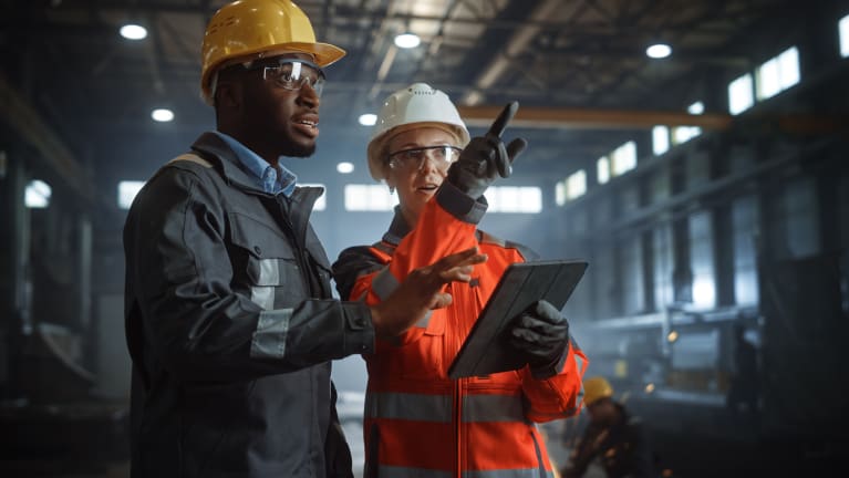 Two manufacturing workers wearing hard hats